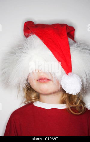 Mädchen trägt Weihnachtsmütze über Kopf Stockfoto