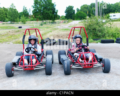 Porträt von zwei jungen in Gokarts auf dem richtigen Weg Stockfoto