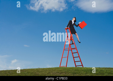 Geschäftsfrau mit roten Aktentasche stehen auf Leiter Stockfoto