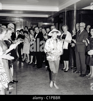 1950er Jahren Cruising. Beifahrerin, die Teilnahme an ein lustiges "raten die Tracht" Wettbewerb wird durch andere Gäste klatschten. Stockfoto