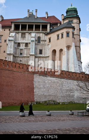 Zwei Nonnen, vorbei an den Mauern der Burg Wawel, Krakau, Polen. Stockfoto