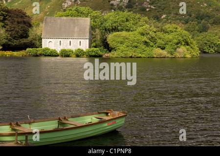 Republik von Irland, County Cork, Gougane Barra, Kirche mit Boot im Vordergrund Stockfoto