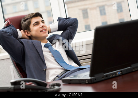 Porträt von intelligenten Unternehmer denken über etwas mit Lächeln im Büro Stockfoto