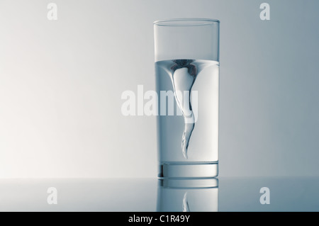 Glas mit Quellwasser auf blauem Grund Stockfoto