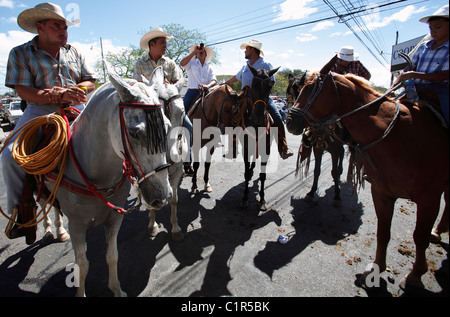 Costa-Ricanischen Männer auf Pferden trinken Bier nach der Teilnahme an einer Pferdeparade während eines bürgerlichen Festivals in Liberia, Costa Rica Stockfoto
