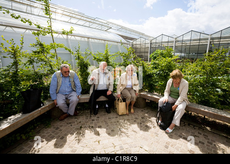 Personen / Person / Besucher / Besucher / Tourist / Touristen sitzen / sitzen / Ruhe / ruhen auf Gartenbank an RHS Wisley Surrey. UK Stockfoto