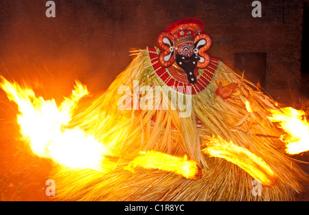 Theyyam Performer umgeben von Fackeln tanzt eine Variation der das Feuerritual trat bei Festivals in North Kerala. Stockfoto