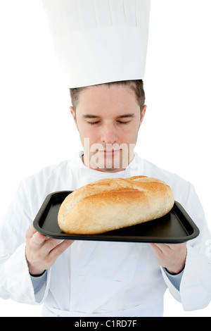 Ein männlicher Koch mit geschlossenen Augen Geruch bei Brot vor weißem Hintergrund Stockfoto
