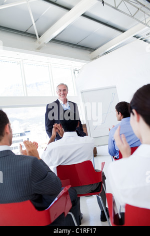 Business-Leute applaudieren die Lautsprecher nach der Konferenz Stockfoto