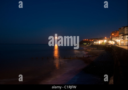 Cromer Meeresküste von Cromer Pier bei Mondaufgang am frühen Abend gesehen. Stockfoto