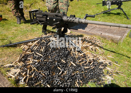 Ein.50 Kaliber Browning Maschinengewehr mit einem Haufen von abgebrannten Fällen und Links. Stockfoto