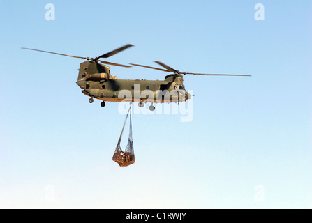 Ein CH-47 Chinook der Royal Air Force transportiert eine Schlinge Last von Paletten. Stockfoto