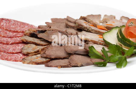Geräucherte Fleisch- und Wurstwaren im Zuschnitt auf Teller mit Grün Stockfoto