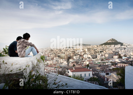 Touristen sitzen auf den Felsen mit Blick auf Athen und Mount Lycabettus Stockfoto