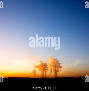 industrielle Kühltürme bei Sonnenuntergang Stockfoto