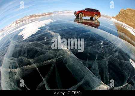 Red Offroader Fahren entlang der klaren Eis eines zugefrorenen See. Baikalsee, Insel Olchon, Sibirien, Russland Stockfoto