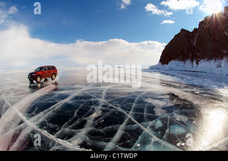 Red Offroader Fahren entlang der klaren Eis eines zugefrorenen See. Baikalsee, Insel Olchon, Sibirien, Russland Stockfoto