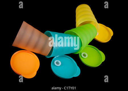 Farbe Kunststoff-Gläser liegt in Reihe auf schwarzem Hintergrund Stockfoto