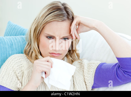 Kranke Frau auf einem Sofa liegend mit Gewebe Stockfoto