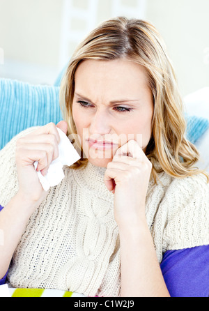 Niedergeschlagenen Frau auf einem Sofa liegend mit Gewebe Stockfoto