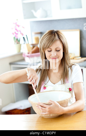 Porträt von einer netten Frau, die einen Kuchen in der Küche kochen Stockfoto