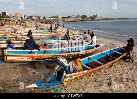 Bunt bemalten Fischerboote säumen den Strand auf dem Fischmarkt in Dakar, Senegal Stockfoto