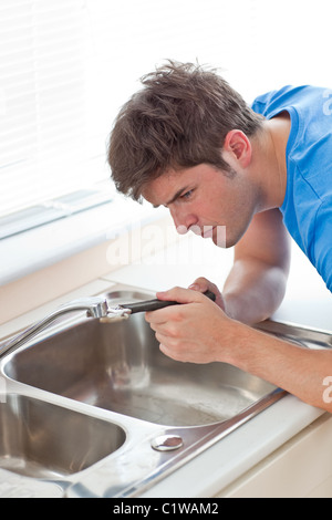 Manuelle Mann Reparatur seiner Spülbecken in der Küche Stockfoto