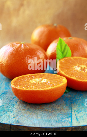 Mandarinen mit Blättern auf einem Holztisch Stockfoto