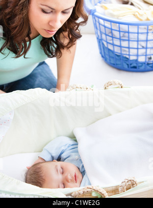 Aufmerksame Mutter ein Auge auf ihr Baby schläft in der Wiege Stockfoto