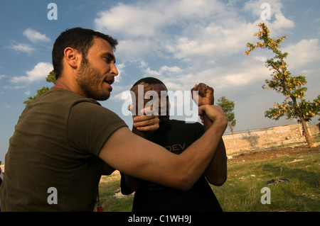 Der Leiter der Einav Levy-Delegation von Natan Humanitarian Aid unterrichtete Krav Maga ein israelisches Selbstverteidigungssystem, das für die israelische Armee entwickelt wurde, um eine Gruppe haitianischer Männer zu bilden, die als Sicherheitskräfte des provisorischen Lagers in Port-au-Prince ausgebildet wurden, das für Überlebende eines Erdbebens der Stärke 7,0 errichtet wurde, das Haiti am 12. Januar 2010 heimsuchte Stockfoto