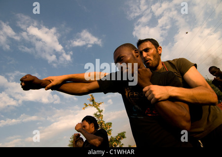 Der Leiter der Einav Levy-Delegation von Natan Humanitarian Aid unterrichtete Krav Maga ein israelisches Selbstverteidigungssystem, das für die israelische Armee entwickelt wurde, um eine Gruppe haitianischer Männer zu bilden, die als Sicherheitskräfte des provisorischen Lagers in Port-au-Prince ausgebildet wurden, das für Überlebende eines Erdbebens der Stärke 7,0 errichtet wurde, das Haiti am 12. Januar 2010 heimsuchte Stockfoto