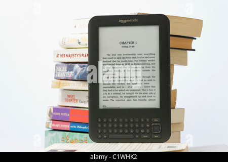 Ein Amazon Kindle Ebook-Reader und einen Stapel von Taschenbüchern auf weißem Hintergrund. Das Kindle 3 Modell. NUR ZU REDAKTIONELLEN ZWECKEN Stockfoto