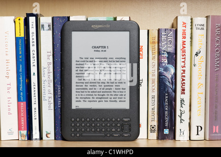 Ein Amazon Kindle Ebook Reader auf einem Bücherregal mit Taschenbüchern. Dies ist das Kindle 3-Modell. NUR ZU REDAKTIONELLEN ZWECKEN Stockfoto