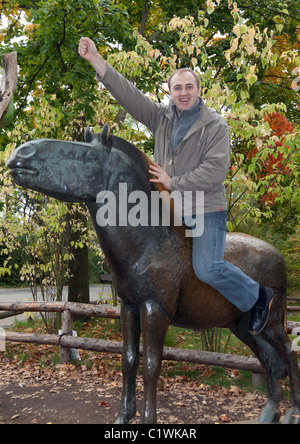 Mann auf einem Messing-Pferd-Denkmal im Herbst in Prag Stockfoto