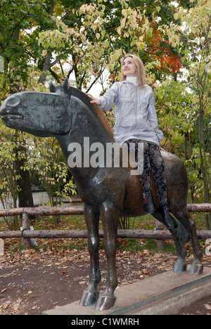 Mädchen auf dem Messing-Pferd-Denkmal im Herbst in Prag Stockfoto