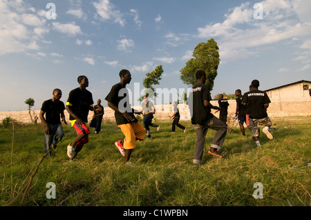 Einav Abgabe delegation Manager von Natan Internationale Humanitäre Hilfe, die an einer körperlichen Übung mit einer Gruppe von haitianischen Männer geschultes Sicherheitspersonal der behelfsmäßigen Lager für Überlebende einer Stärke von 7,0 Erdbeben, das Haiti am 12. Januar 2010 Am Stadtrand von Port-au-Prince gefunden werden Stockfoto