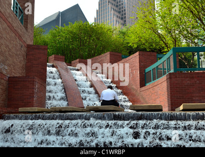 Eine Person, die Ruhe inmitten der Wasserfall im Stadtzentrum von Houston laufen. Texas, USA. Stockfoto