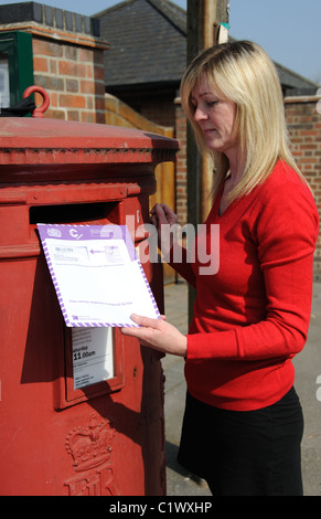 Tag des Zensus. Frau, die Entsendung einer abgeschlossenen 2011 Volkszählung dokumentieren in einen Royal Mail-Briefkasten Stockfoto