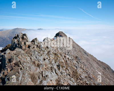 Scrambler auf der Messer Kante Arete von Crib Goch über eine Cloud-Inversion auf die klassischen Snowdon Horseshoe route. Stockfoto