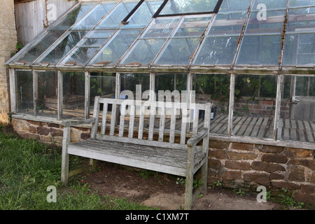 Eine alte vernachlässigt Holzbank in einer Ecke des Gartens Stockfoto