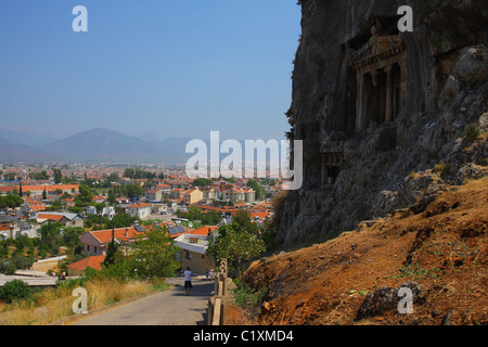 Lykischen Felsen schneiden Gräber von Fethiye (4. Jh. v. Chr.) über die Stadt Fethiye. Mugla, Türkei. Menschen kommen auf der Straße Stockfoto