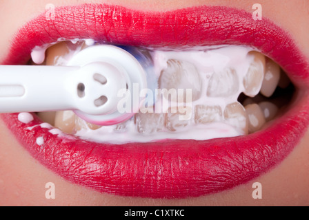 weiße Zähne sind mit einer elektrischen Zahnbürste geputzt. Stockfoto