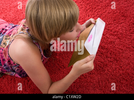 Junge Frau küssen Brief im Umschlag Stockfoto