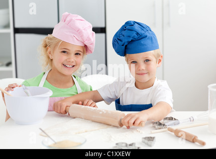 Glücklich Bruder und Schwester bereitet ein Teig steht in der Küche Stockfoto
