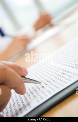 Vertikales Bild der menschlichen Hand halten Sie Stift und Notizen Stockfoto