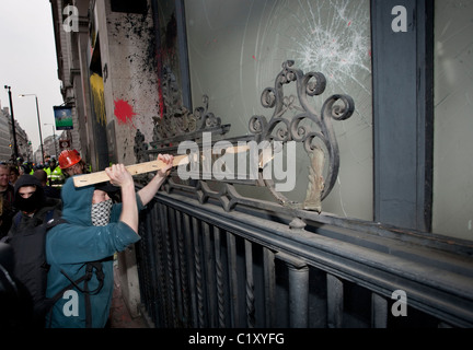 Anti-Kürzungen März 26.03.2011, London, UK A Demonstrant zerschlägt das Fenster der Lloyds Bank am Piccadilly während gewaltsame demonstration Stockfoto