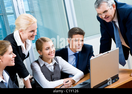 Porträt von zuversichtlich Kollegen Laptop-Monitor im Büro zu betrachten und die Interaktion Stockfoto