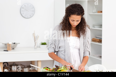 Konzentrierte Frauenbeschneidung Gemüse in der Küche Stockfoto