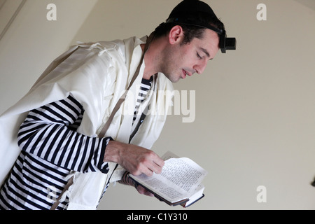 Junger jüdischer Mann mit Tallis und Tefillin Stockfoto