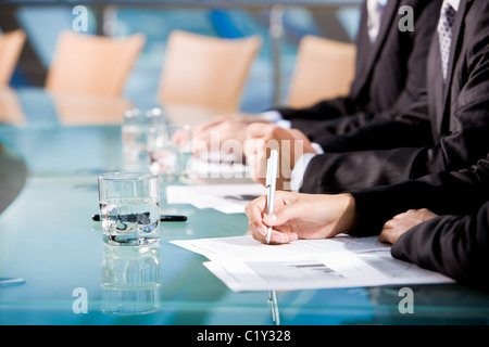 Reihe von menschlichen Händen halten Sie Stift und Notizen mit Glas Wasser in der Nähe von Stockfoto